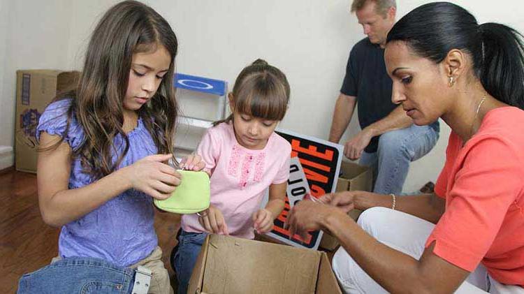 Woman and 2 girls going through a box.