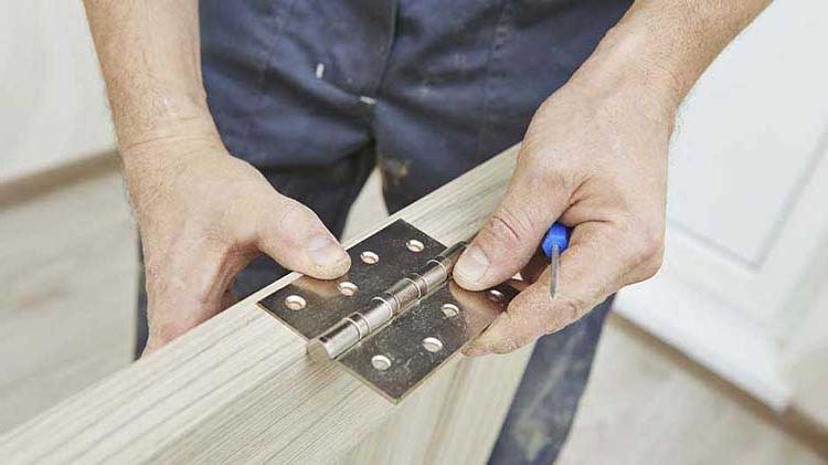 Man installing a door hinge.