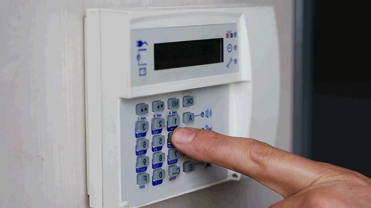 Person entering a code on a home safe keypad.