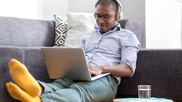 A millennial aged man working on his laptop